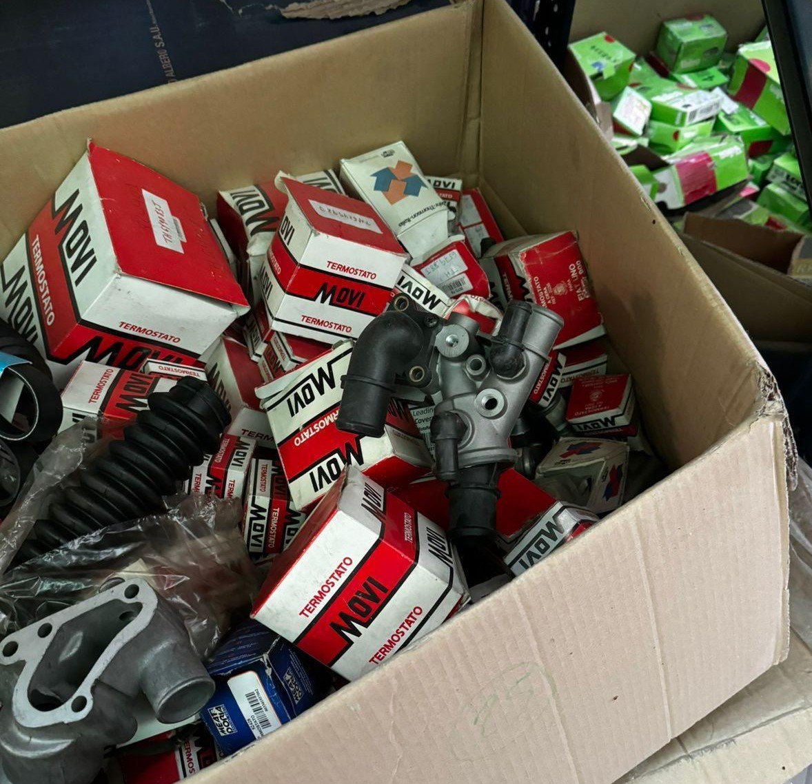 Box of assorted thermostats and engine parts