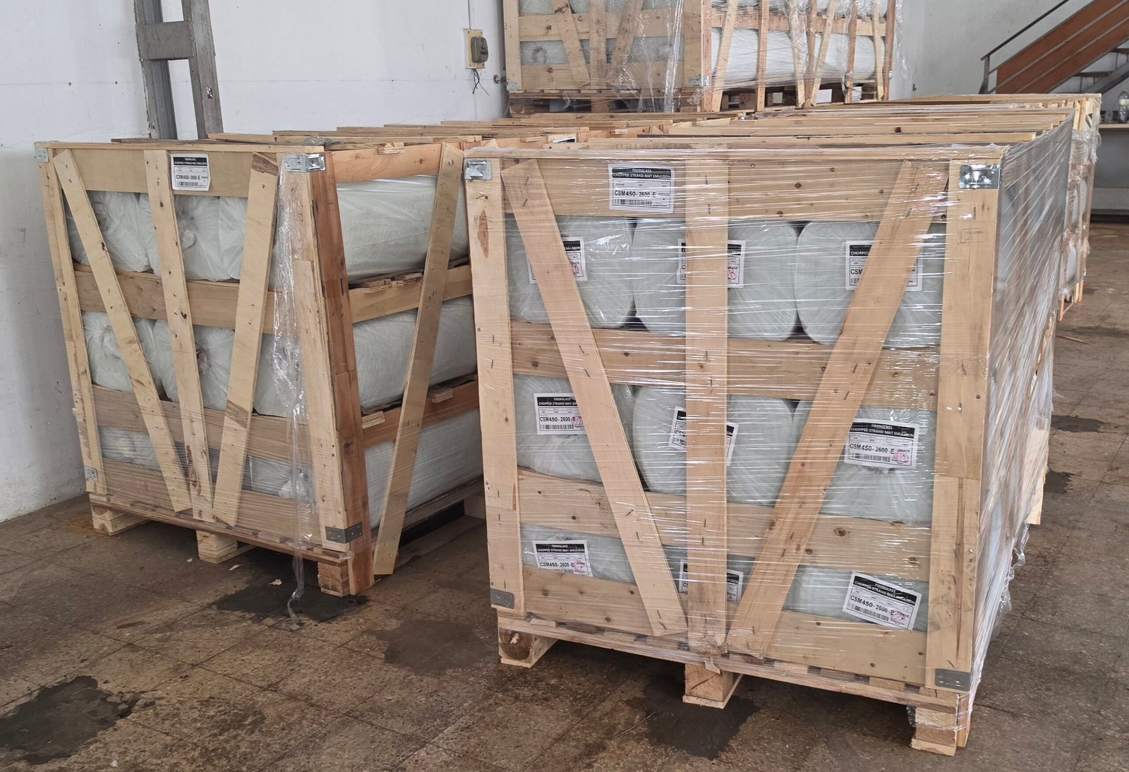 Fiberglass chopped strand mat rolls stock in wooden crates, warehouse