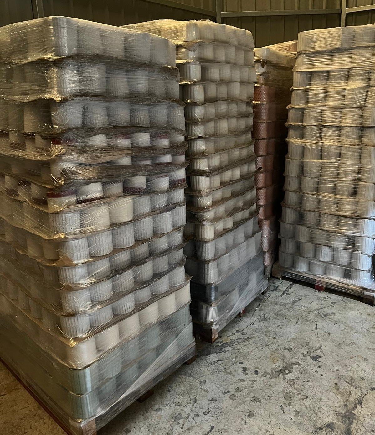 Pallets of glazed stoneware flowerpots wrapped in plastic, warehouse