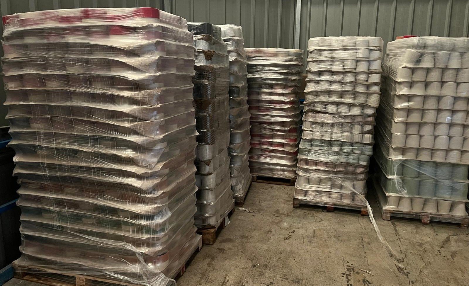 Pallets of glazed stoneware flowerpots, warehouse view