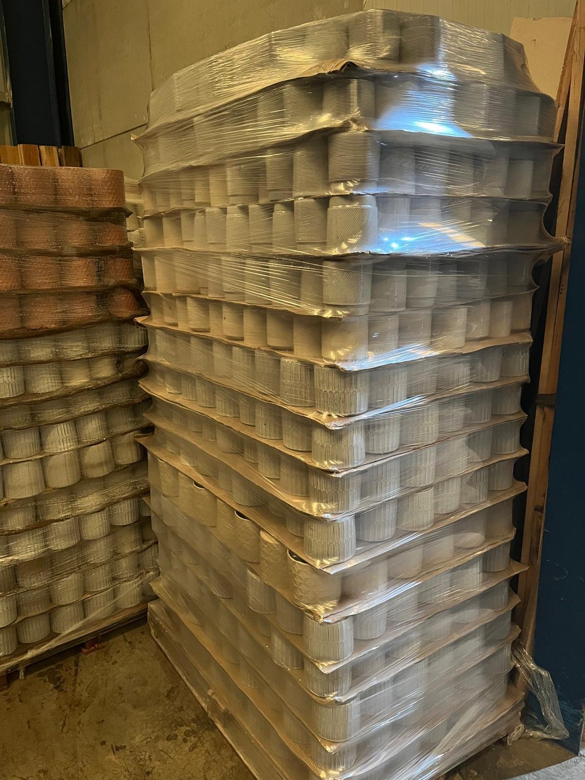 Pallet of glazed stoneware flowerpots wrapped in plastic
